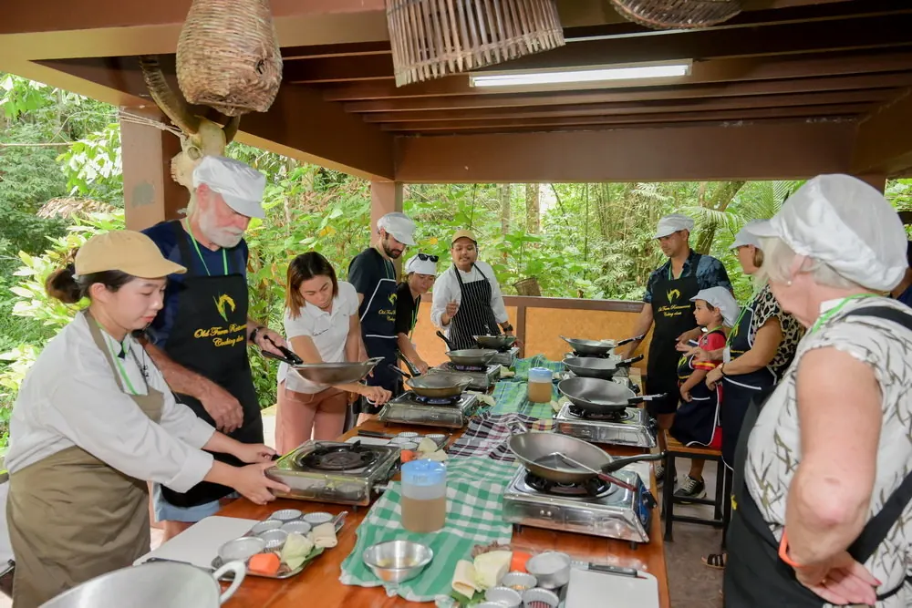Learning Together Adults and a child learning to cook with instructors at Old Phuket Farm