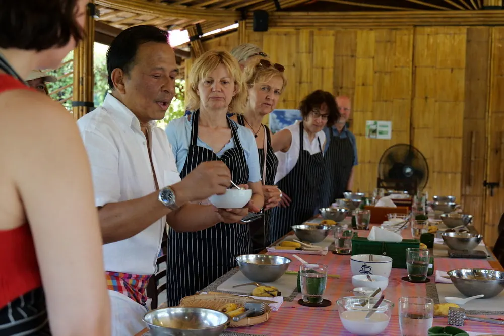 Master Traditional Techniques Visitors watching an instructor explain ingredients in the farm kitchen
